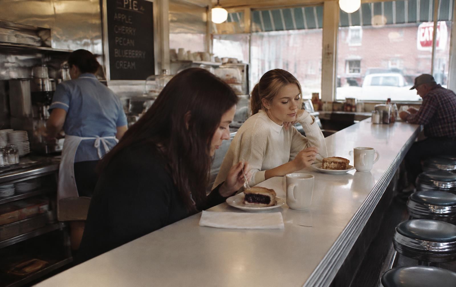 Friends eating pie at a roadside diner counter